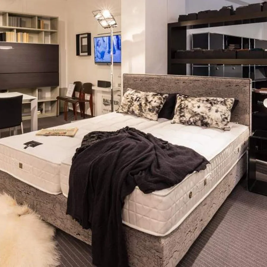 Showroom arredare Essen: Polsterbett mit Kissen und Designleuchten