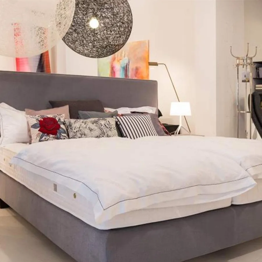 Showroom arredare Essen: Boxspringbett mit Fellteppich im Schlafbereich