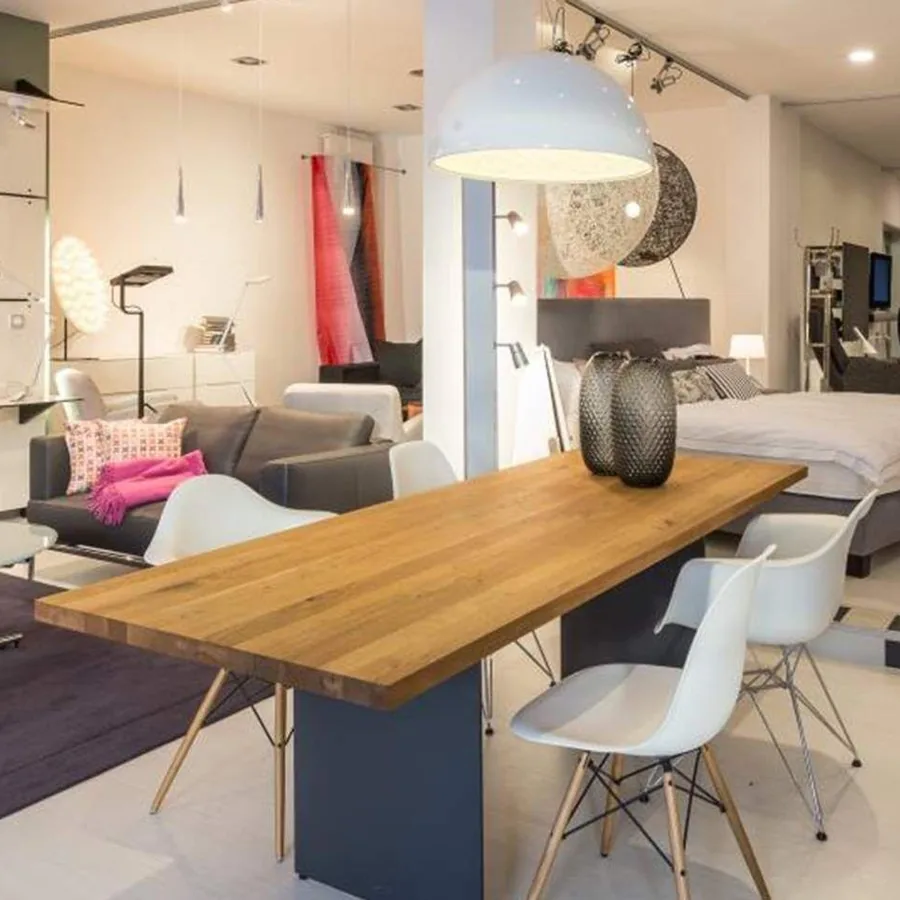 Showroom arredare Essen: Wohnbereich mit Massivholz-Esstisch und Designstühlen